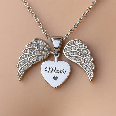A close-up of the CapeGlow® Angel Wings Heart Necklace hanging delicately against a soft, neutral background, highlighting the intricate zircon details and the personalized engraving area, with gentle lighting to emphasize the shine and craftsmanship.